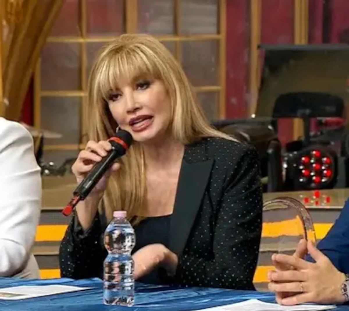 Milly Carlucci sorridente in studio televisivo
